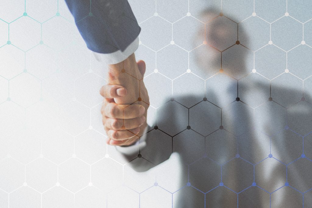 A close-up of a professional handshake between two individuals wearing business suits, symbolizing partnership, agreement, or collaboration. The background is blurred, with a hexagonal network pattern overlay, representing technology, innovation, and connectivity in the business world. The image conveys trust, cooperation, and a modern approach to corporate relationships.