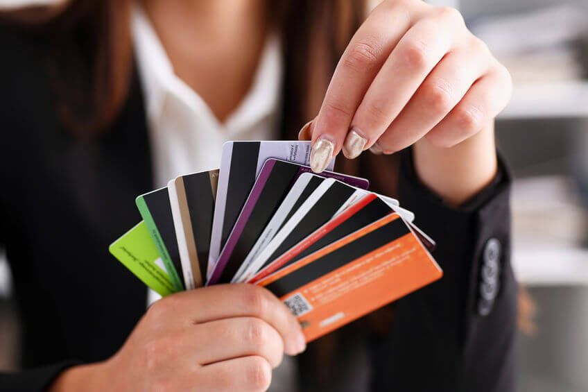 A woman holding multiple colorful credit cards, symbolizing the variety of choices among the best cashback credit cards with no annual fee available in 2025.