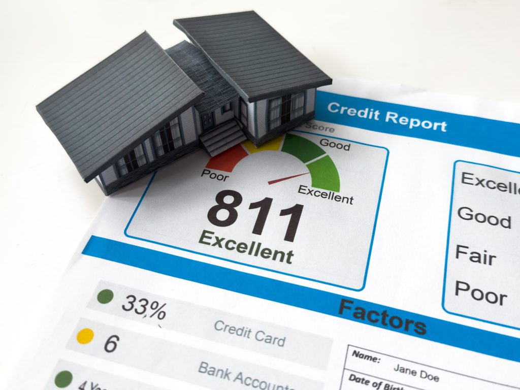 credit report showing an 811 excellent score beside a house model, illustrating what is a good credit score to buy a house.