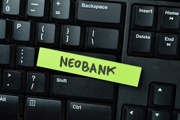 Close-up of a computer keyboard with a green sticky note labeled “Neobank,” illustrating the concept behind what is a neobank and how digital-only banks replace traditional banking services.
