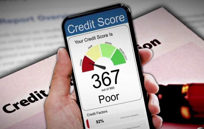 Smartphone displaying a very low credit score of 367 labeled as poor, with credit report documents in the background, illustrating financial challenges often discussed when explaining what is a thin credit file.